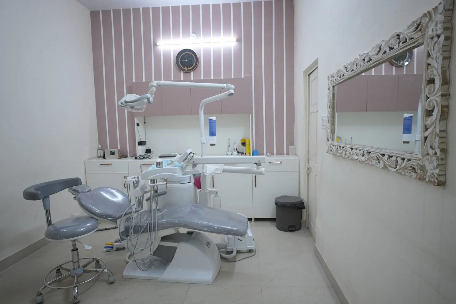 Treatment room with a dental chair and large wall mirror at Your Dentist, Malviya Nagar, Jaipur
