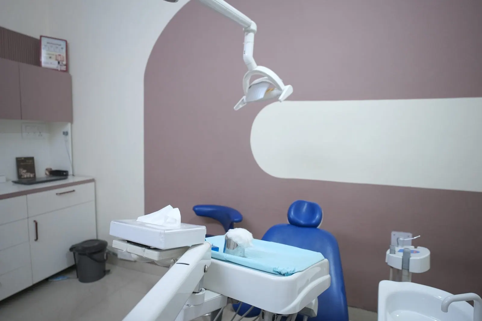 Dental chair with an instrument tray and overhead light at Your Dentist, Malviya Nagar, Jaipur