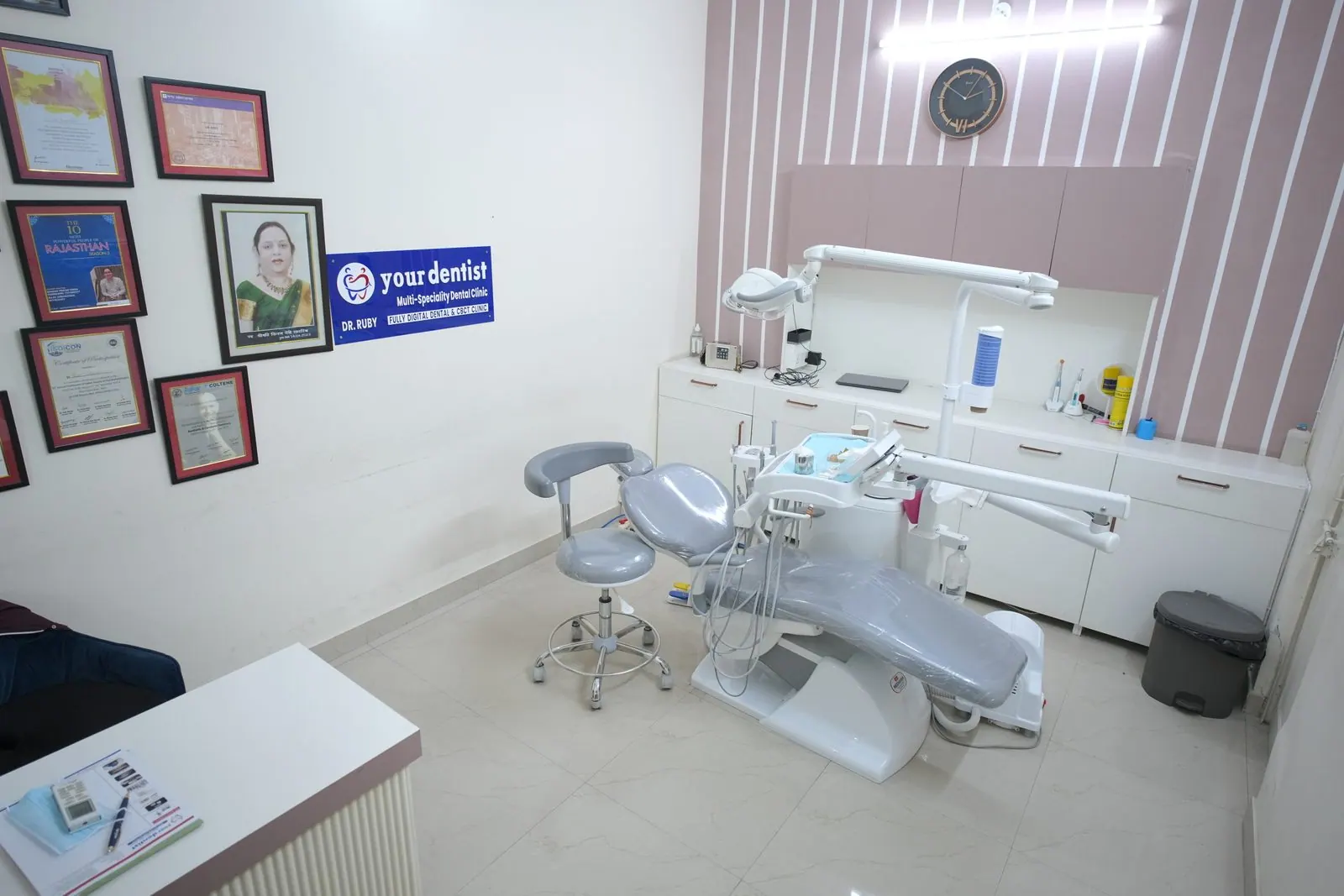 Treatment room with a dental chair and framed certificates on the wall at Your Dentist, Malviya Nagar, Jaipur