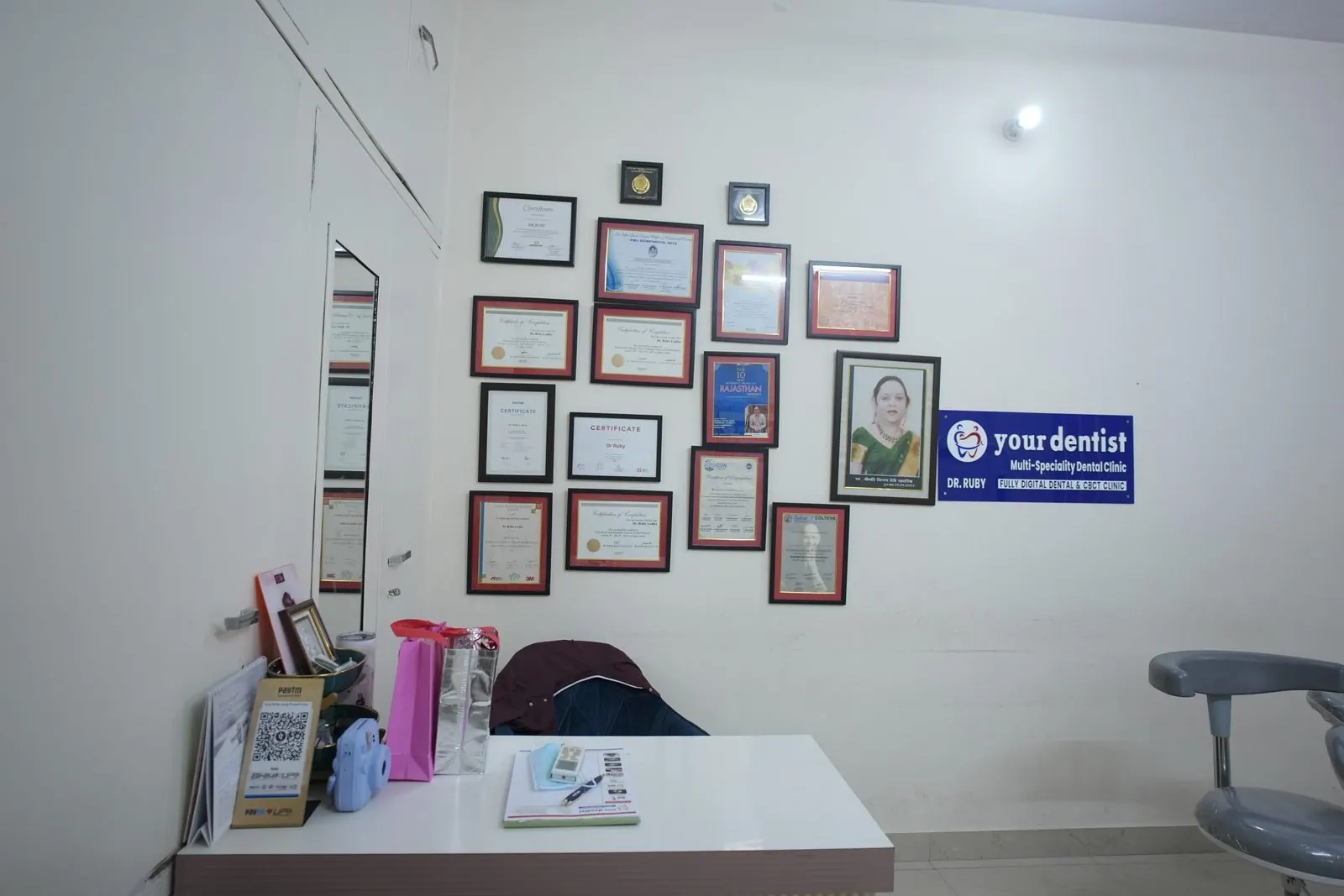 Reception desk with framed certificates on the wall at Your Dentist, Malviya Nagar, Jaipur